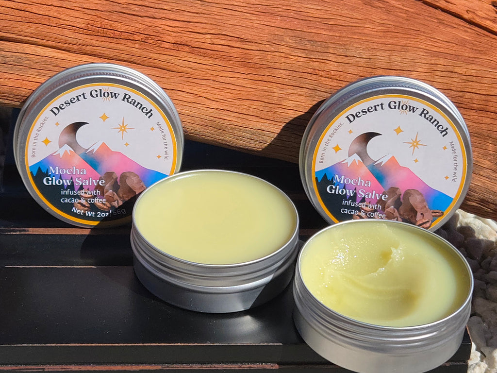Two tins of mocha glow salve organic coffee and chocolate moisturizer with open texture on wood surface