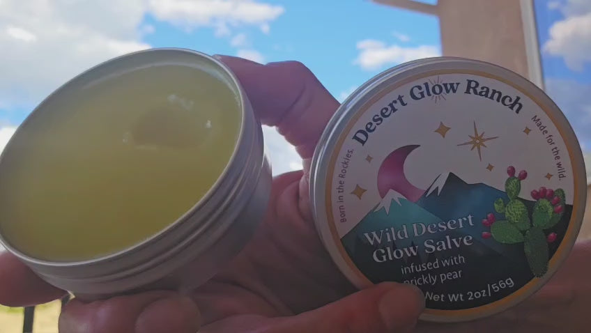 Hand applying Wild Desert Glow Salve prickly pear moisturizer to skin in outdoor setting
